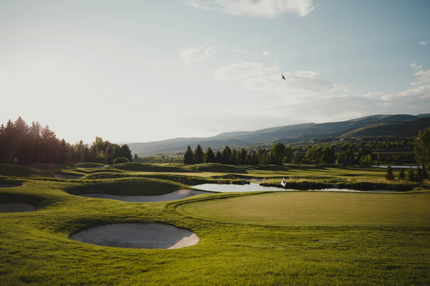 A green in the evening sun, mountains beyond
